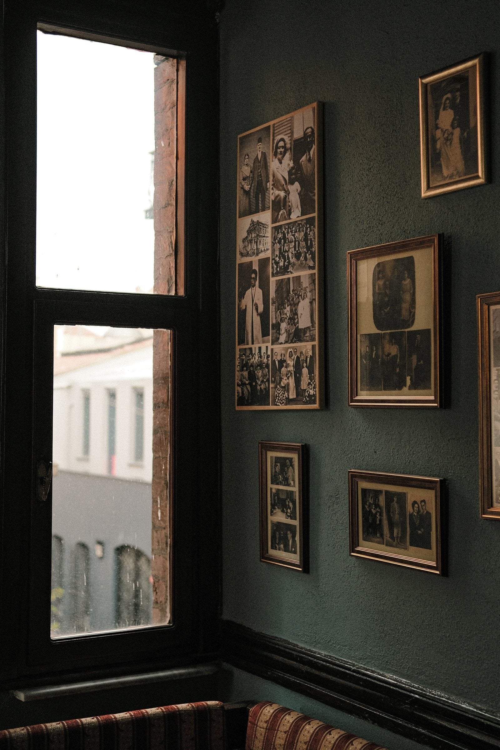 Framed pictures hung on a deep green wall in an Irish home